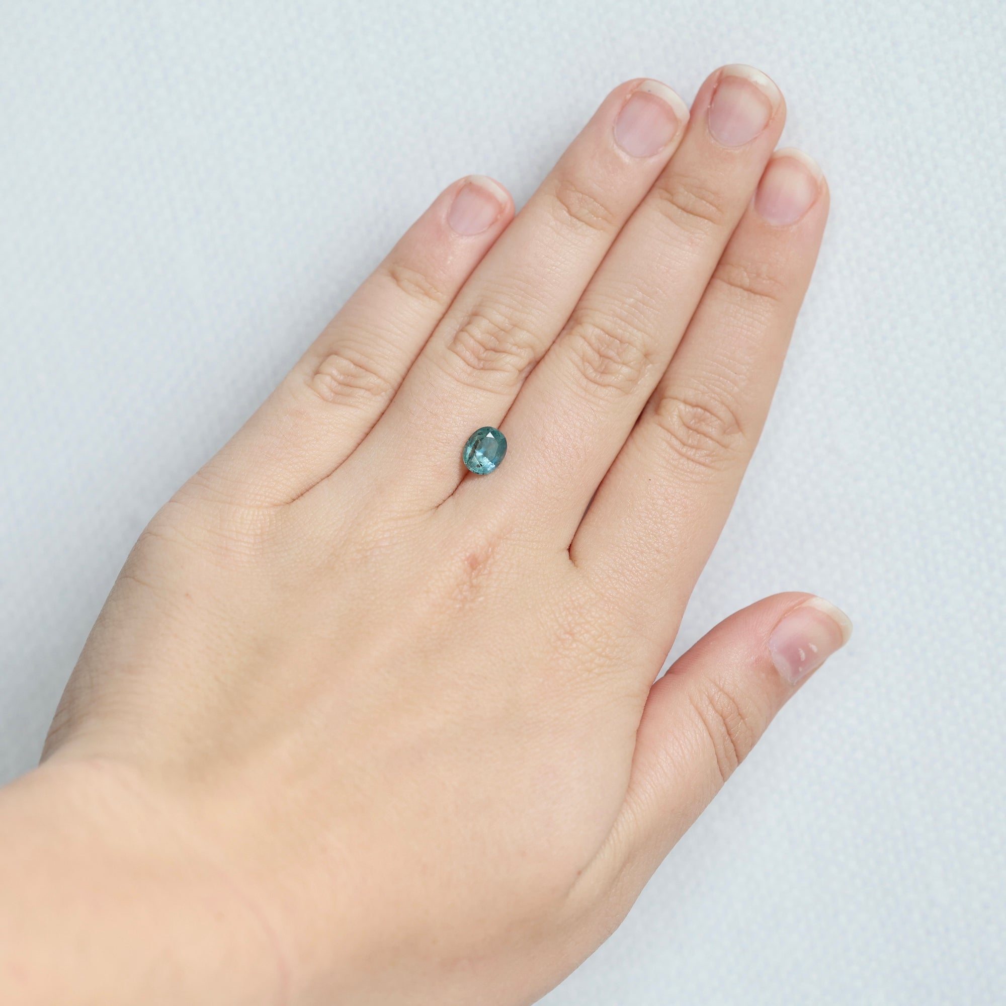 Blue sapphire with brown inclusion on hand