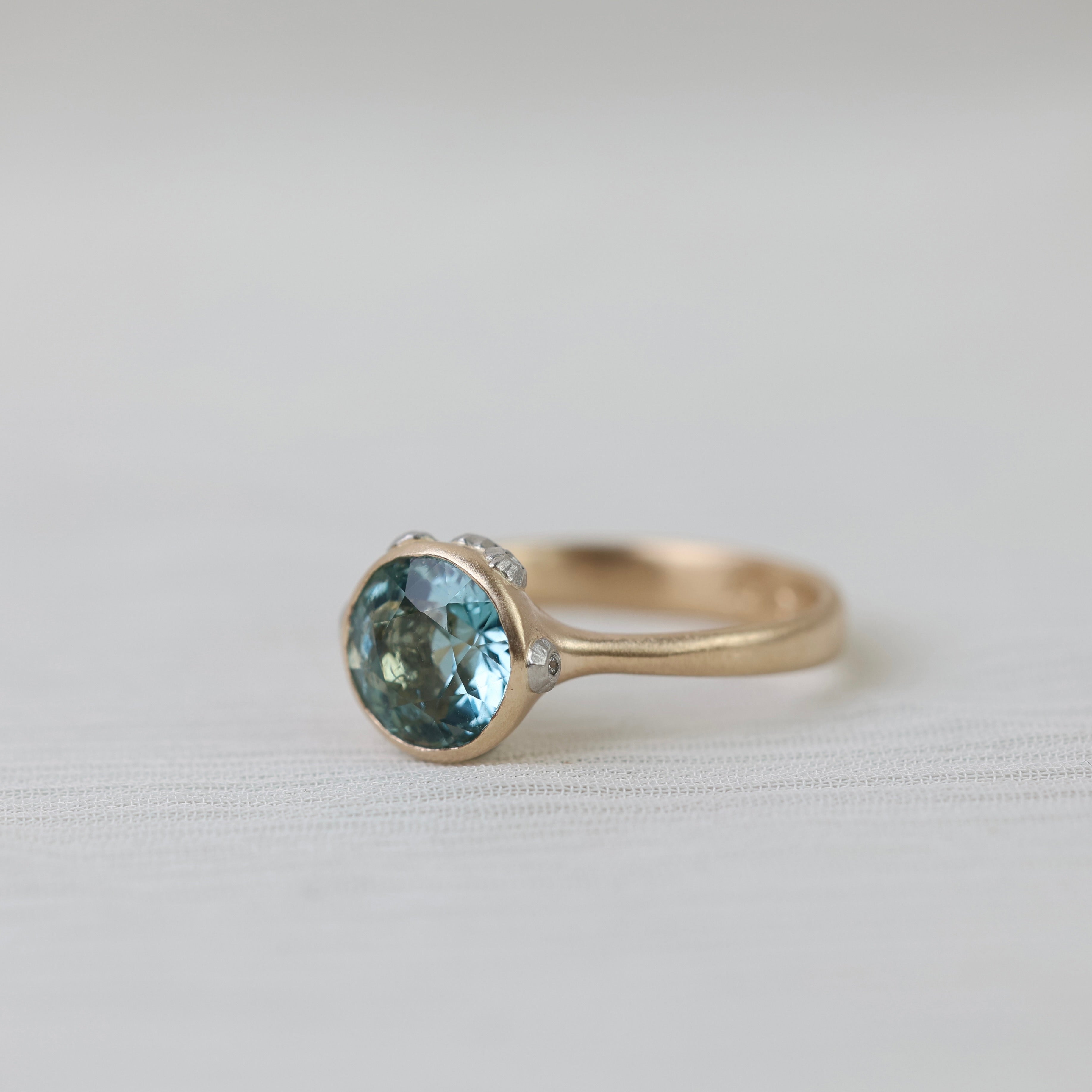 gold ring with blue stone on white background