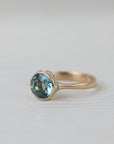 gold ring with blue stone on white background