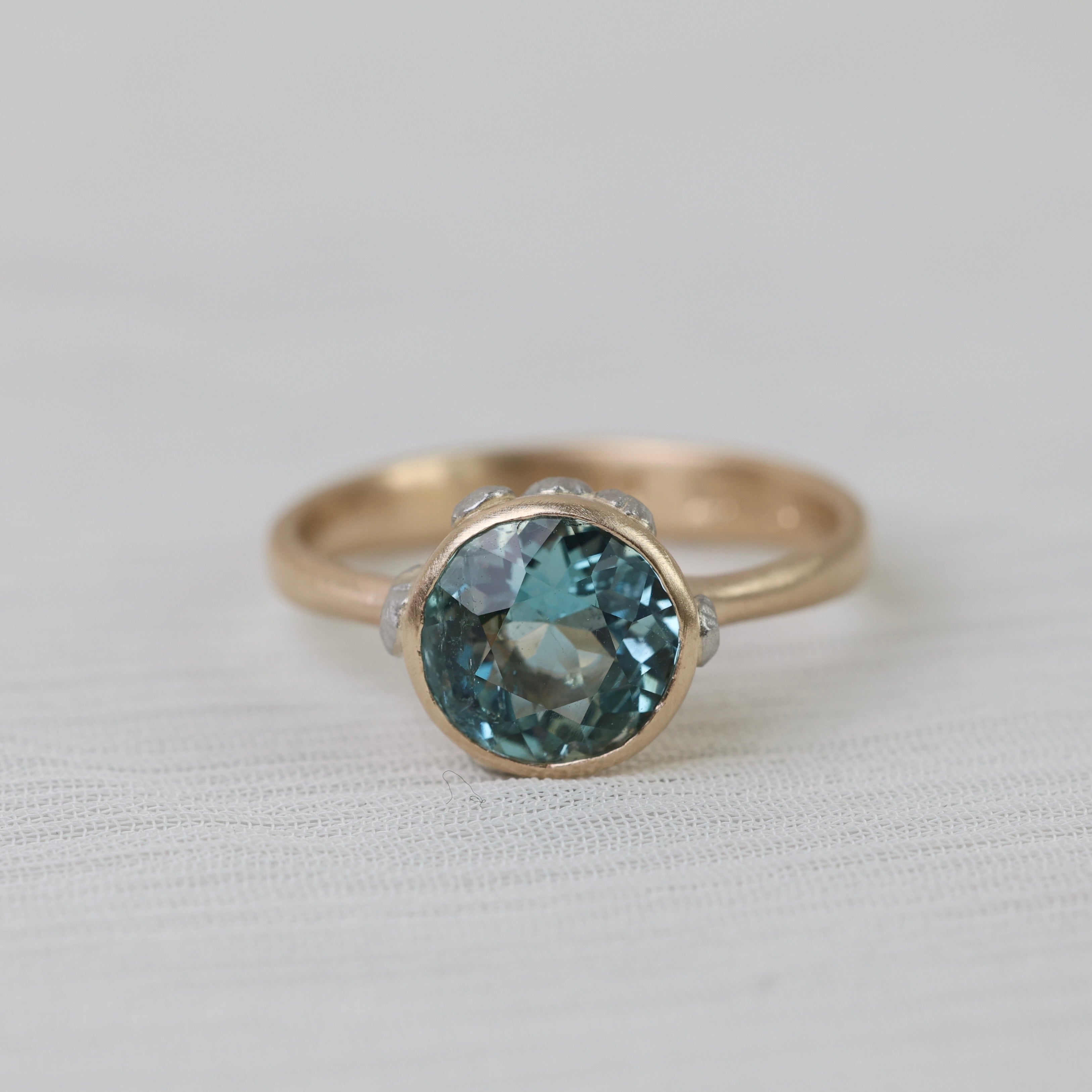 gold ring with blue stone on white background