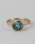 gold ring with blue stone on white background