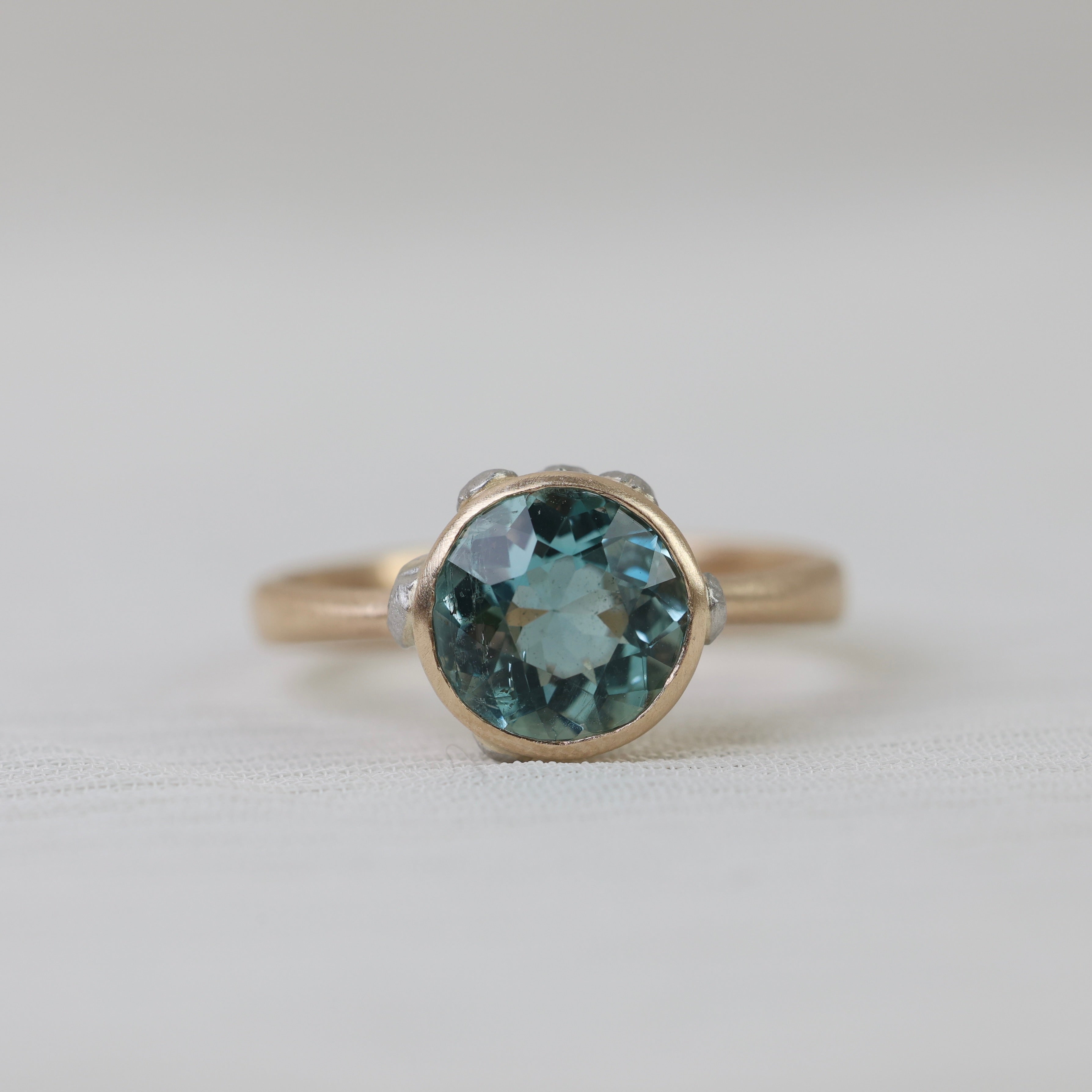 gold ring with blue stone on white background