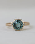 gold ring with blue stone on white background