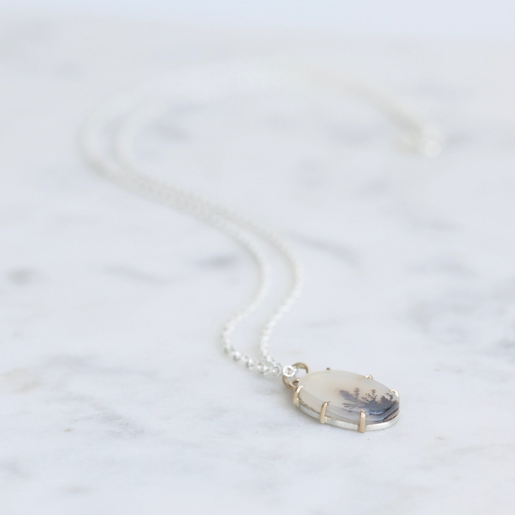 Necklace with a pendant on a light marble background