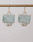 Pair of earrings with rectangular gemstones on a light gray background