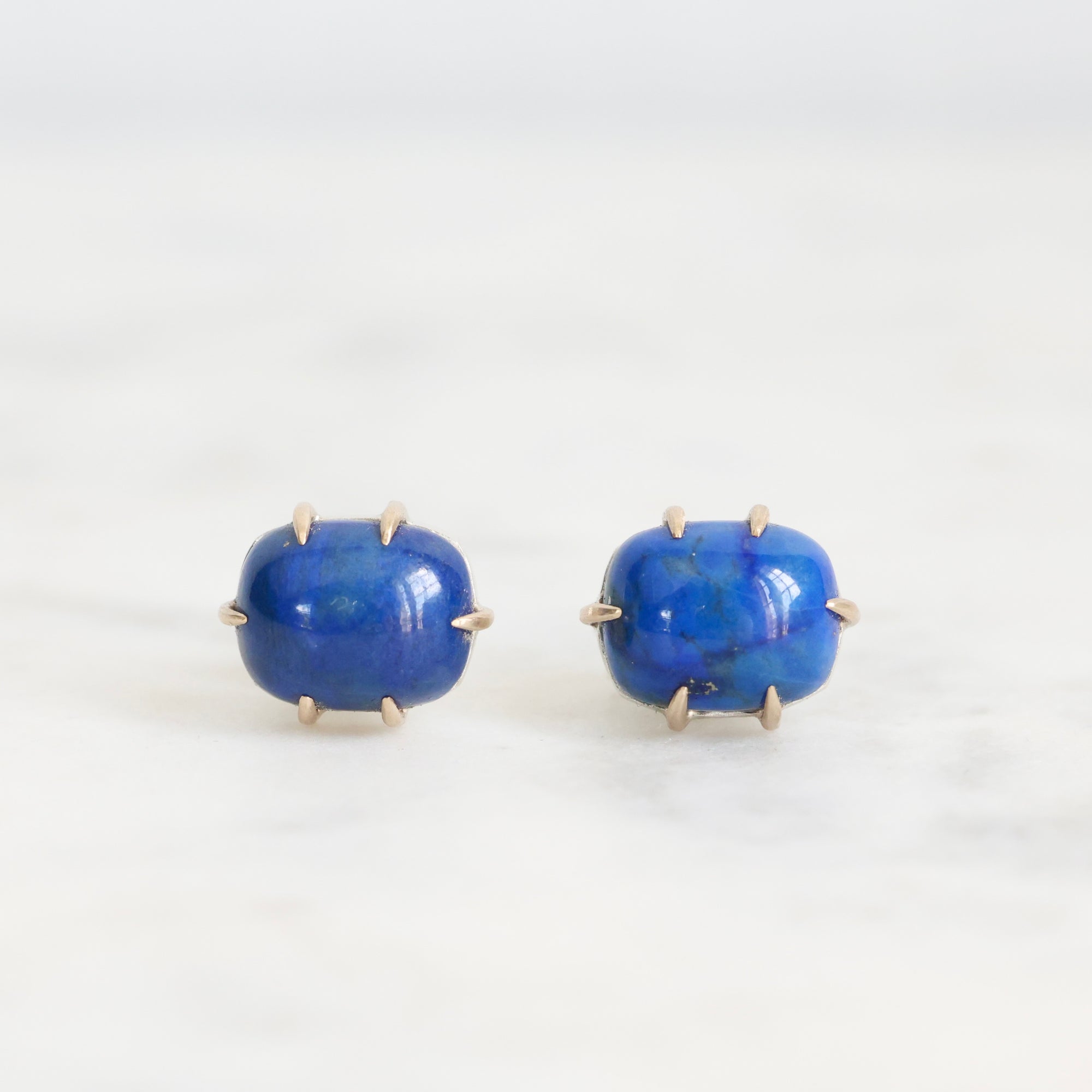 Pair of blue stone earrings on a white background