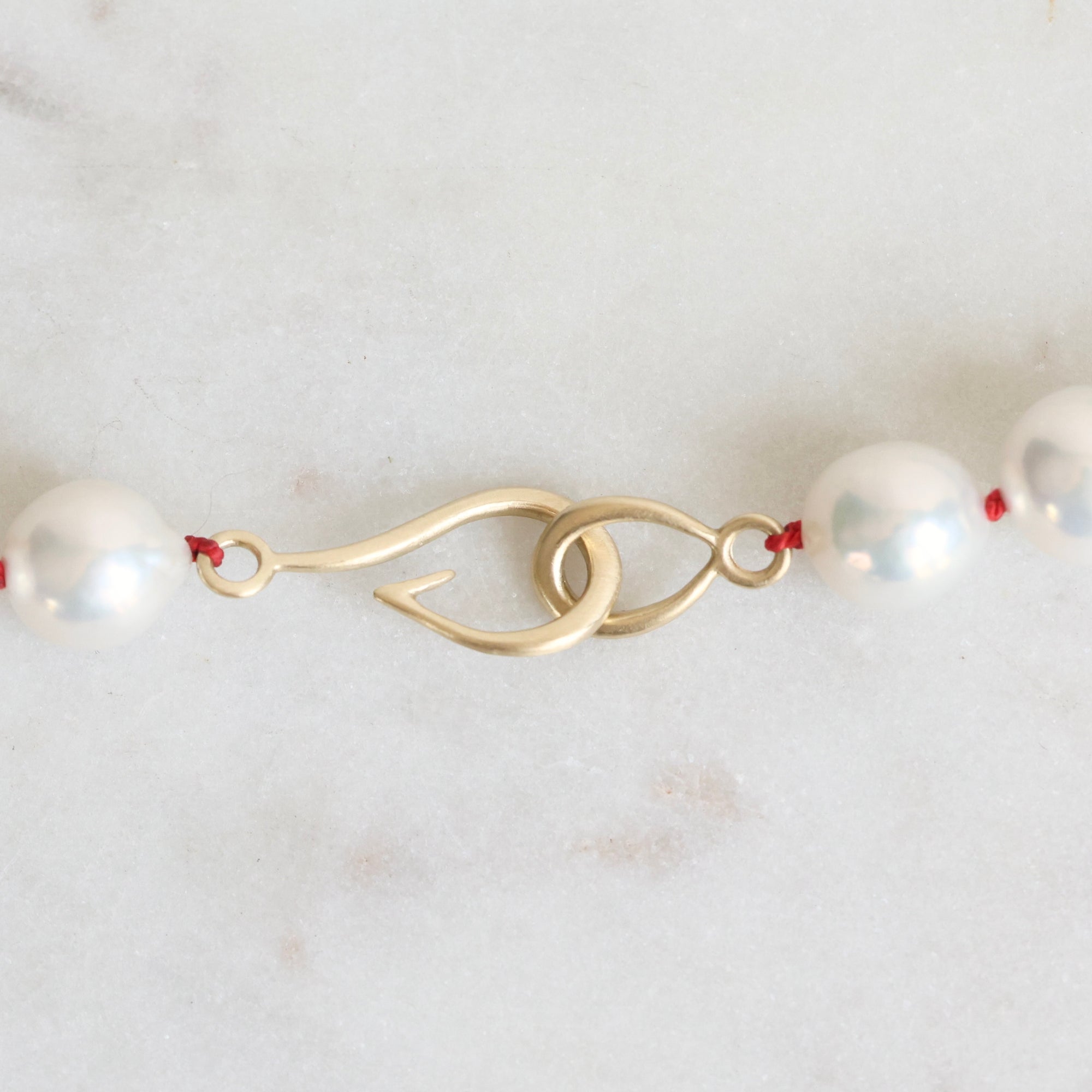 Pearl Strand with gold barnacles and red thread. 
