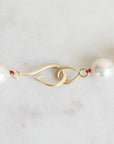 Pearl Strand with gold barnacles and red thread. 