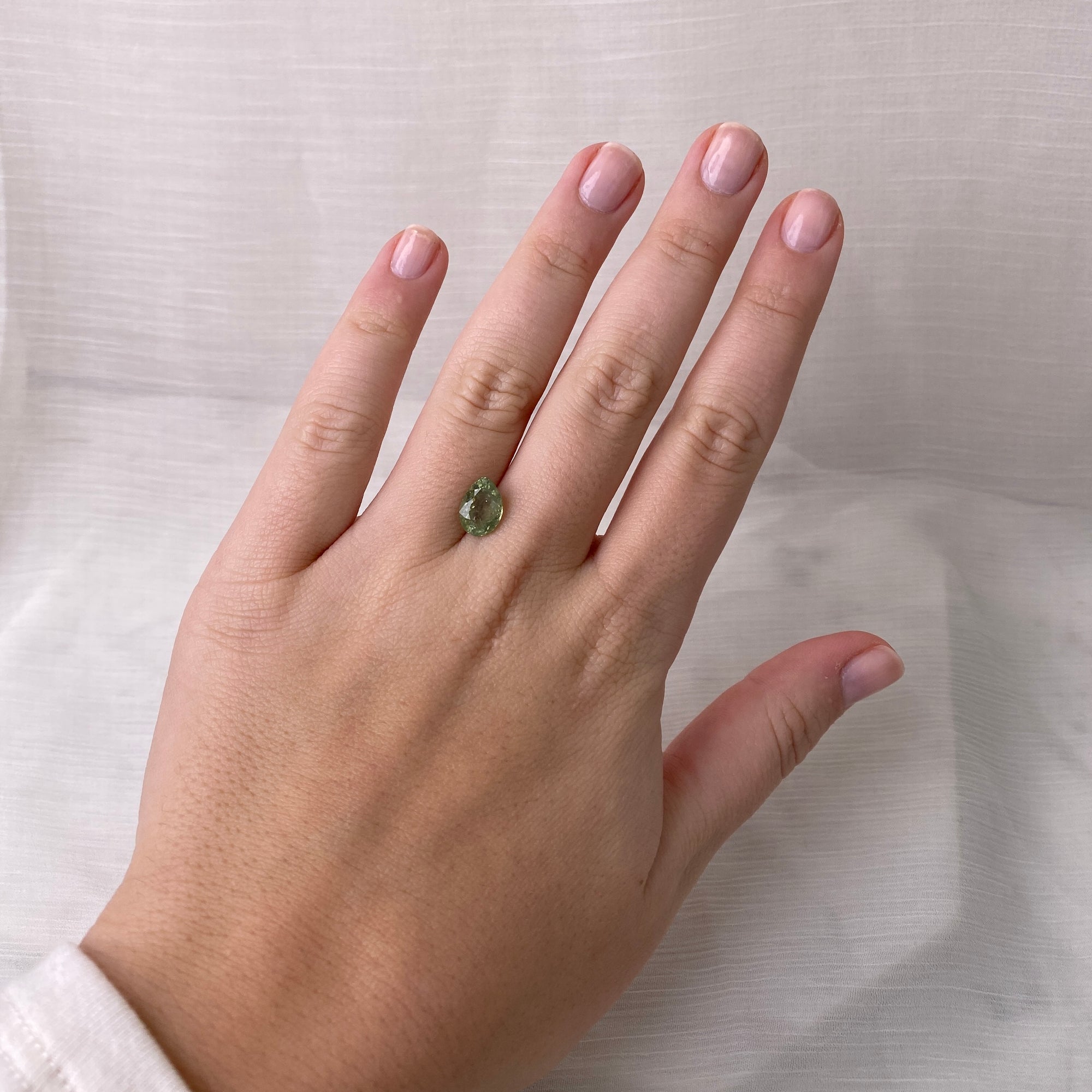 teardrop shaped green stone on hand