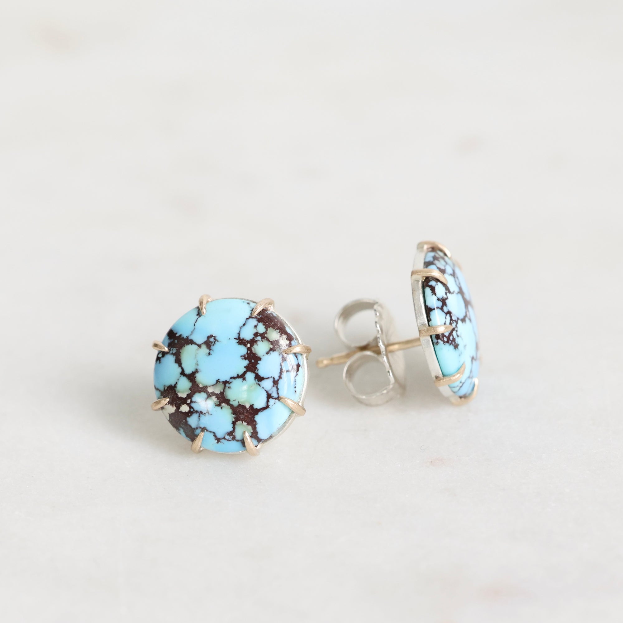 Turquoise stone stud earrings on a light gray background