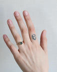 Hand with a ring and a small tattoo on a plain background