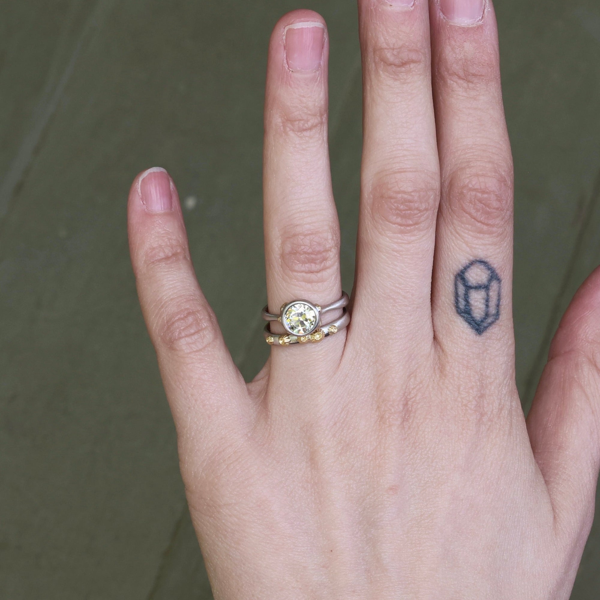 hand wearing diamond ring and wedding band
