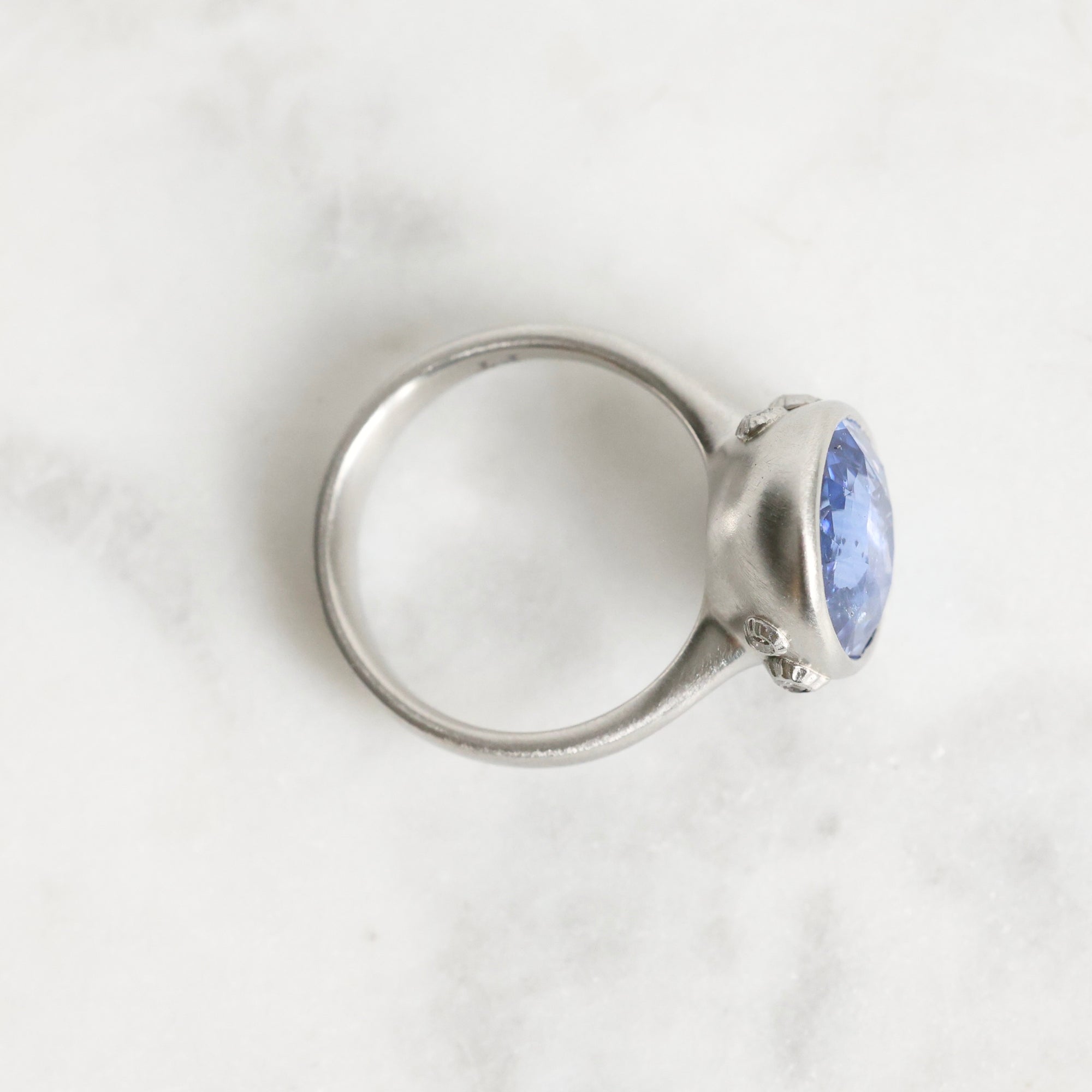 Silver ring with a blue gemstone on a white background