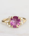 Gold ring with a purple gemstone on a light gray background