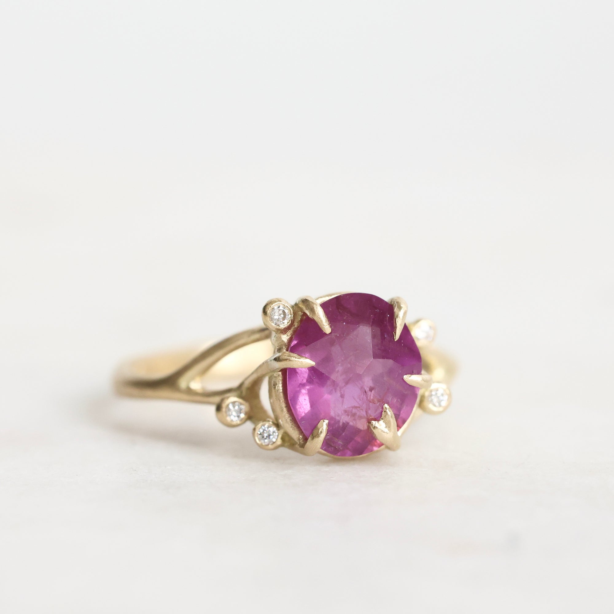 Gold ring with a pink gemstone on a white background