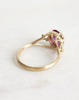 Gold ring with a purple gemstone on a white background
