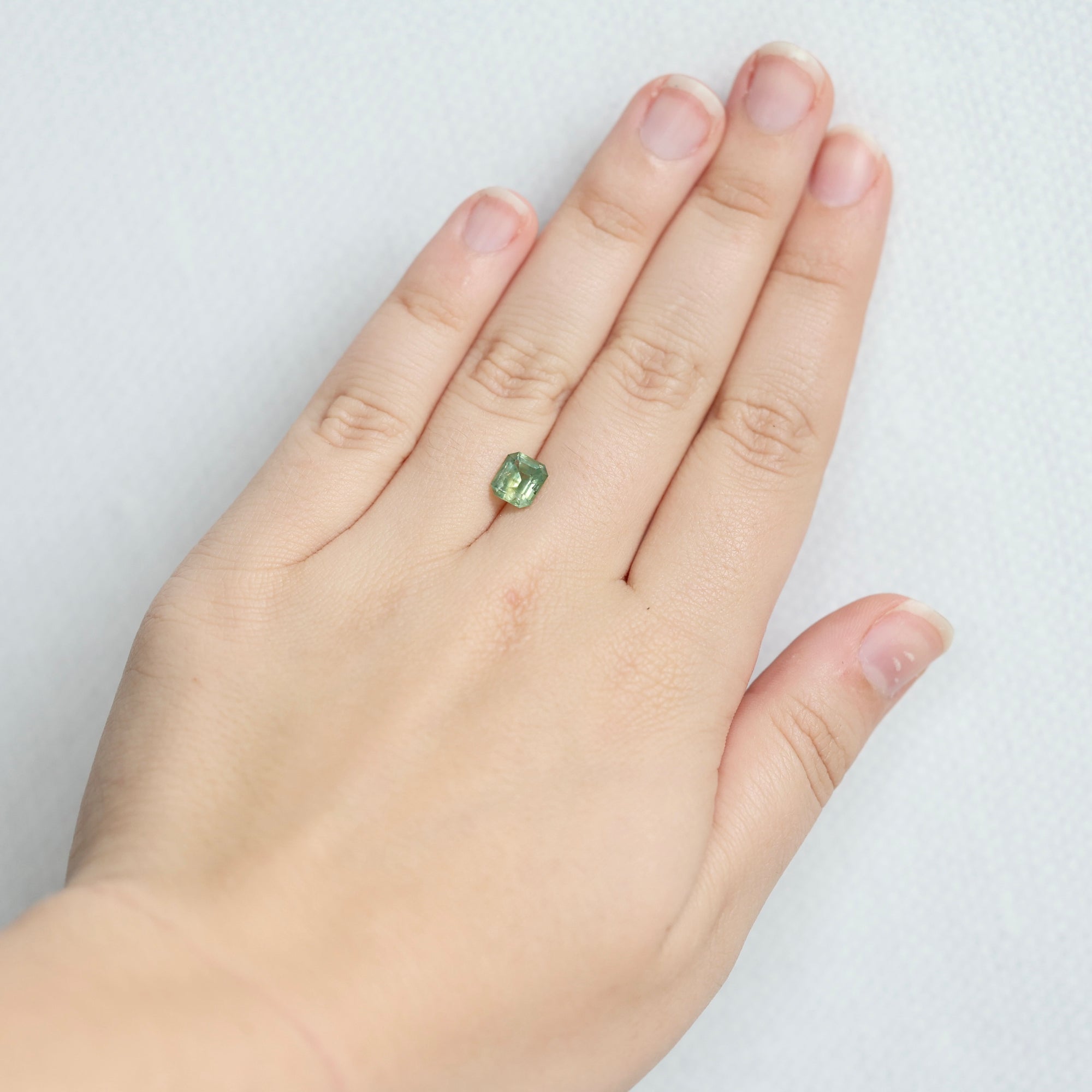 Green emerald cut sapphire on hand 
