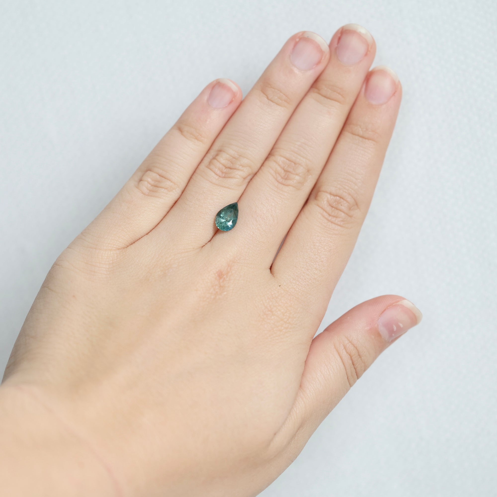 Green pear shaped sapphire on hand