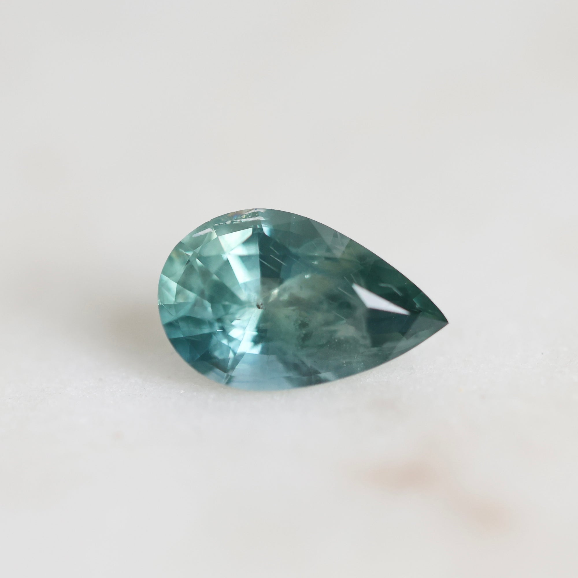 Green/blue pear shaped sapphire with inclusions