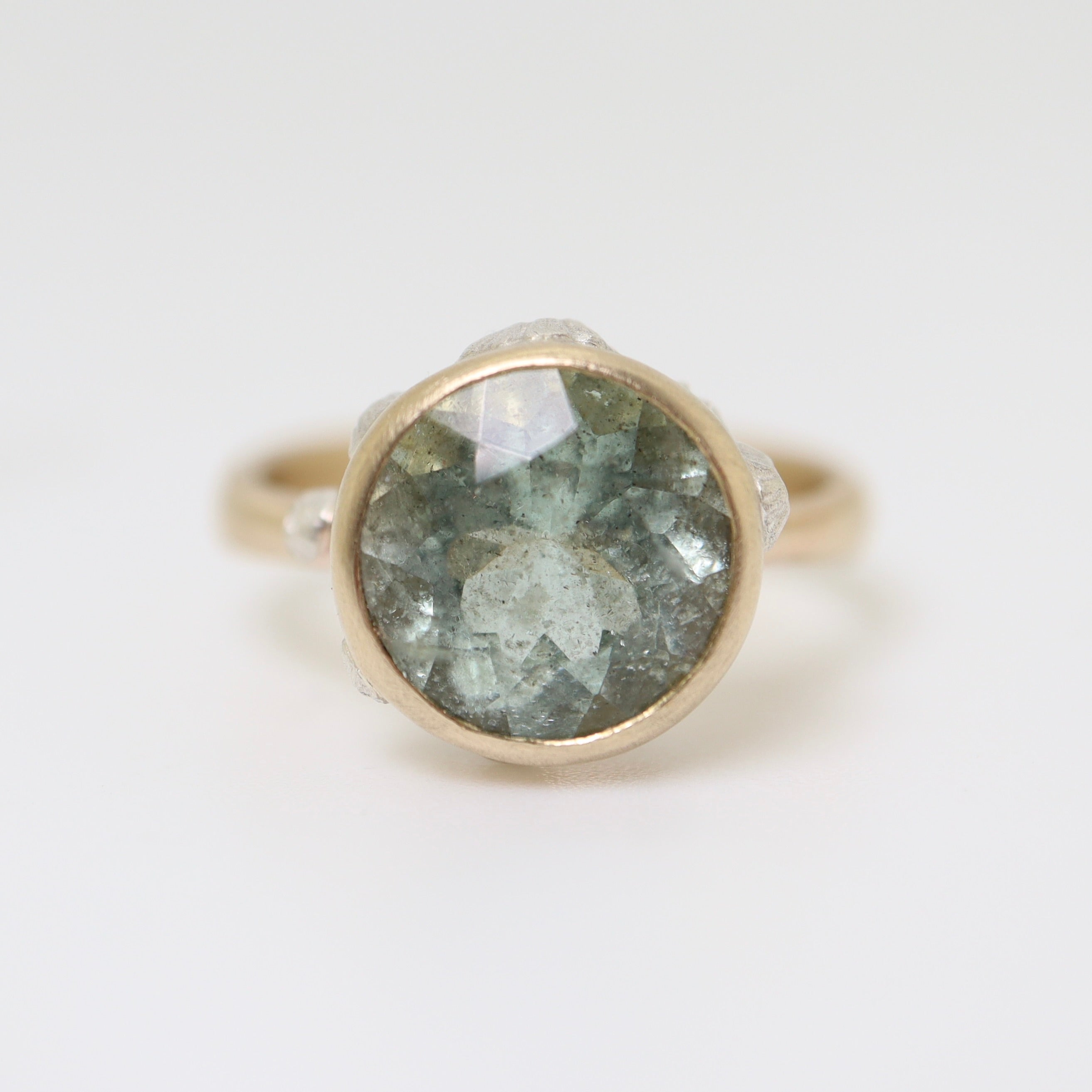 mossy aquamarine ring set in gold with silver barnacles