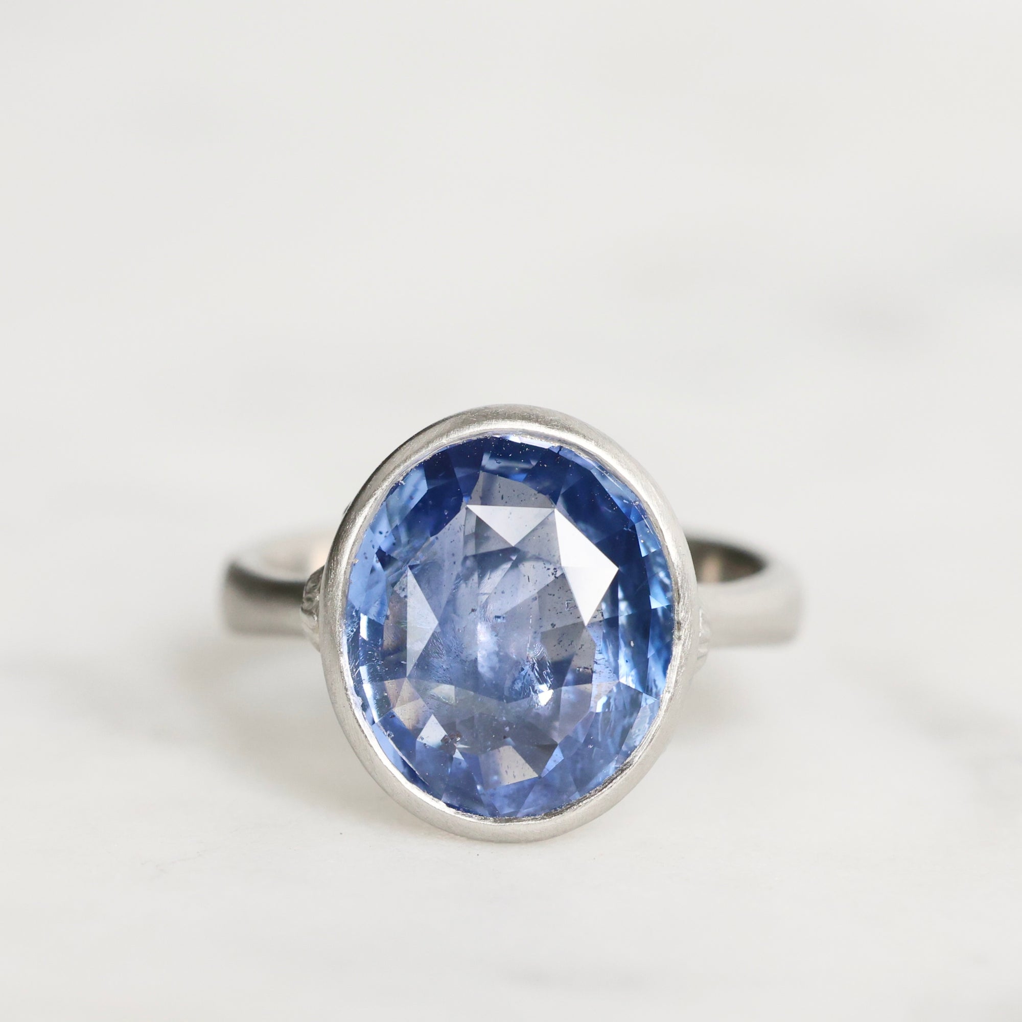 Silver ring with a blue gemstone on a white background