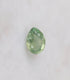 Teardrop-shaped green gemstone on a white background