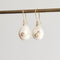 Pearl earrings with gold accents on a gray background