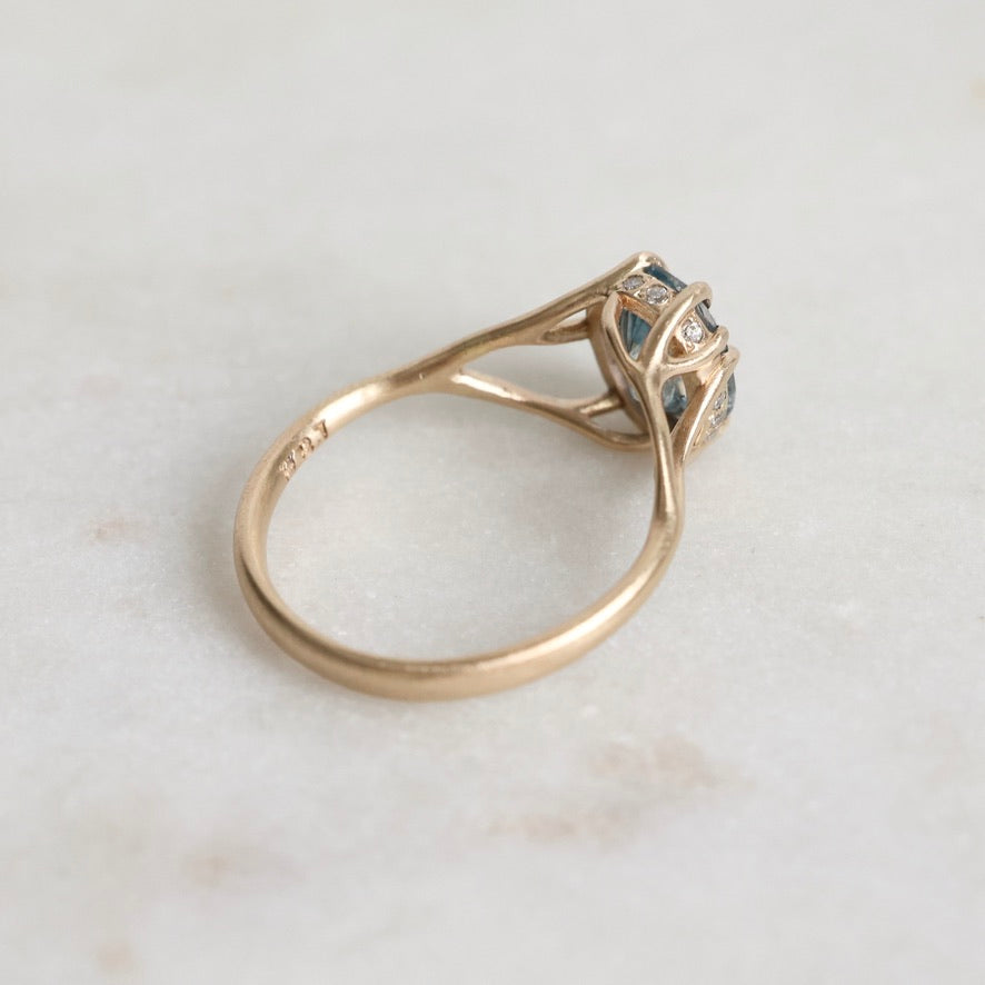 Gold ring with gemstone on a light marble background