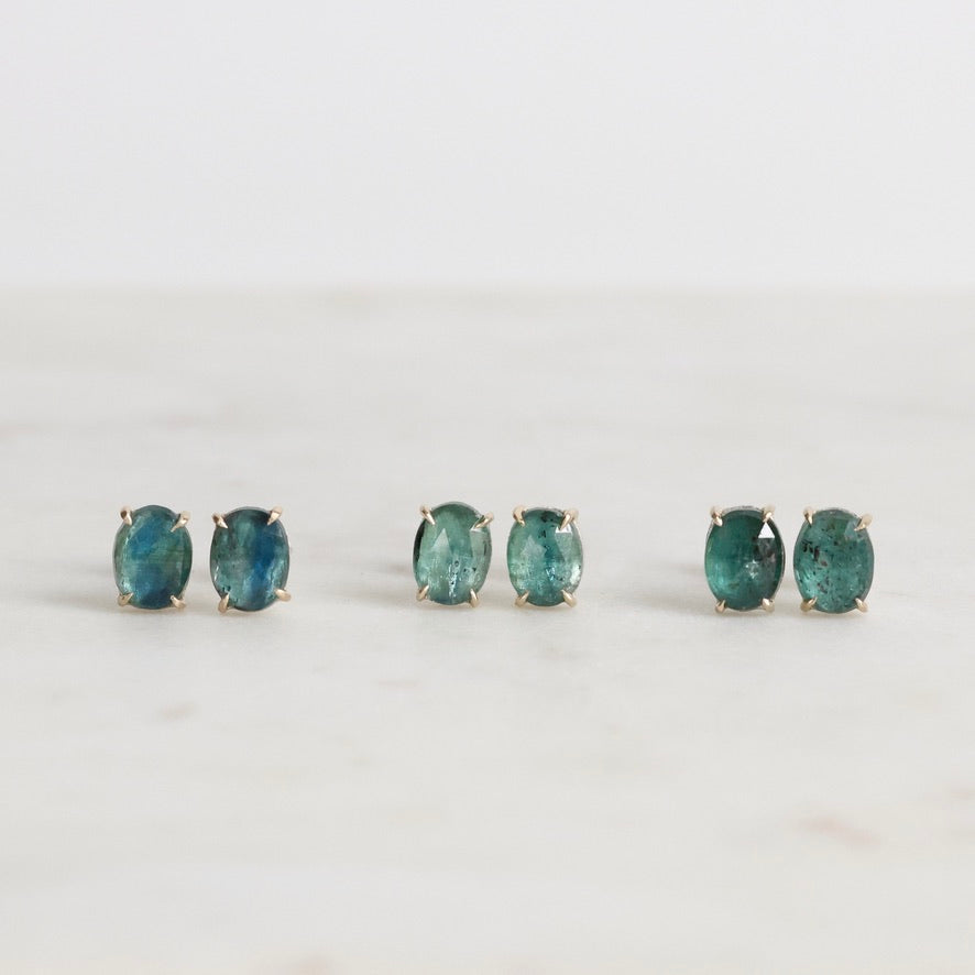 Pair of green gemstone earrings on a white background