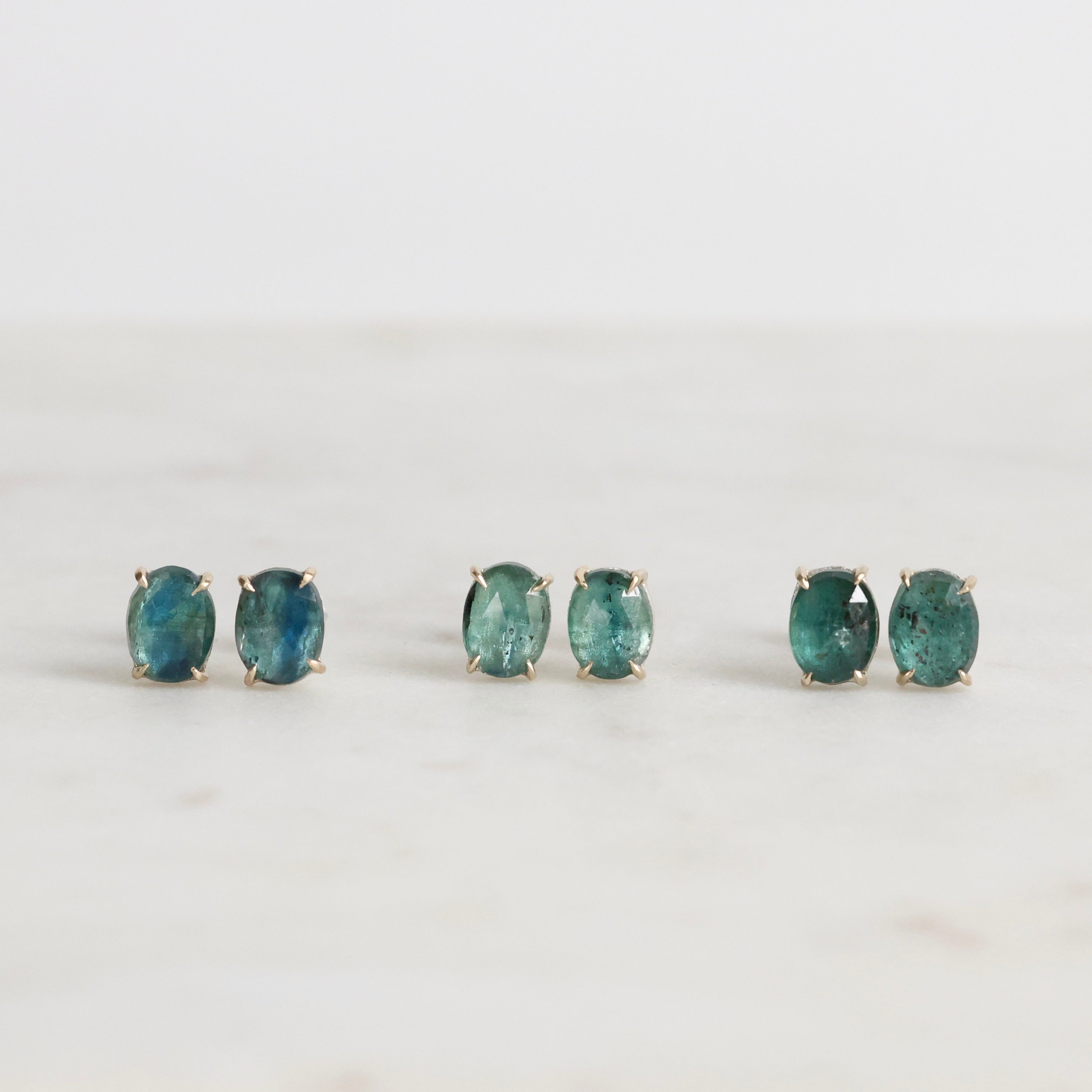 Pair of green gemstone earrings on a white background