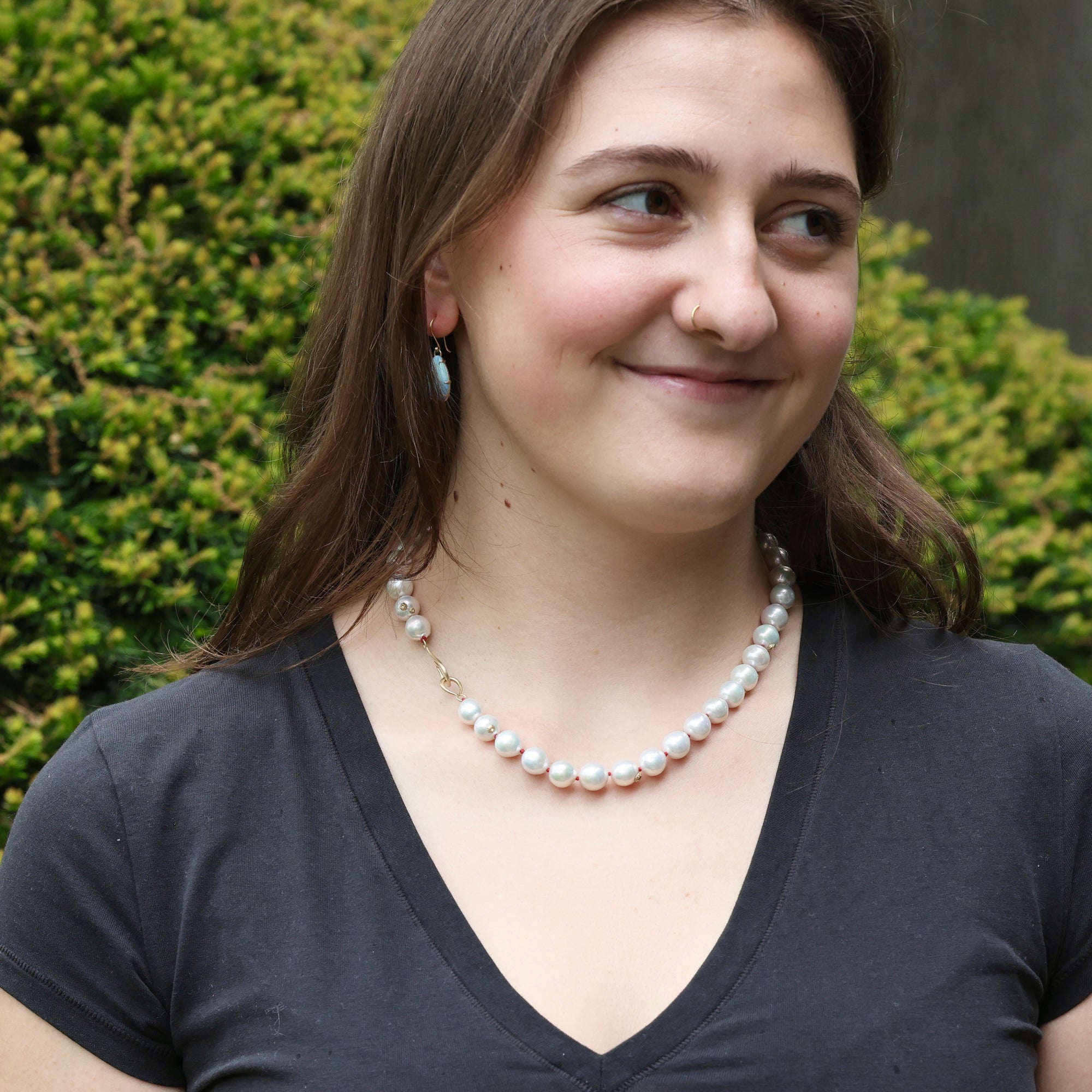 woman wearing strand of white pearls outside