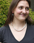 woman wearing strand of white pearls outside
