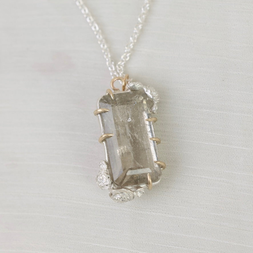 Necklace with a clear stone pendant on a light gray background
