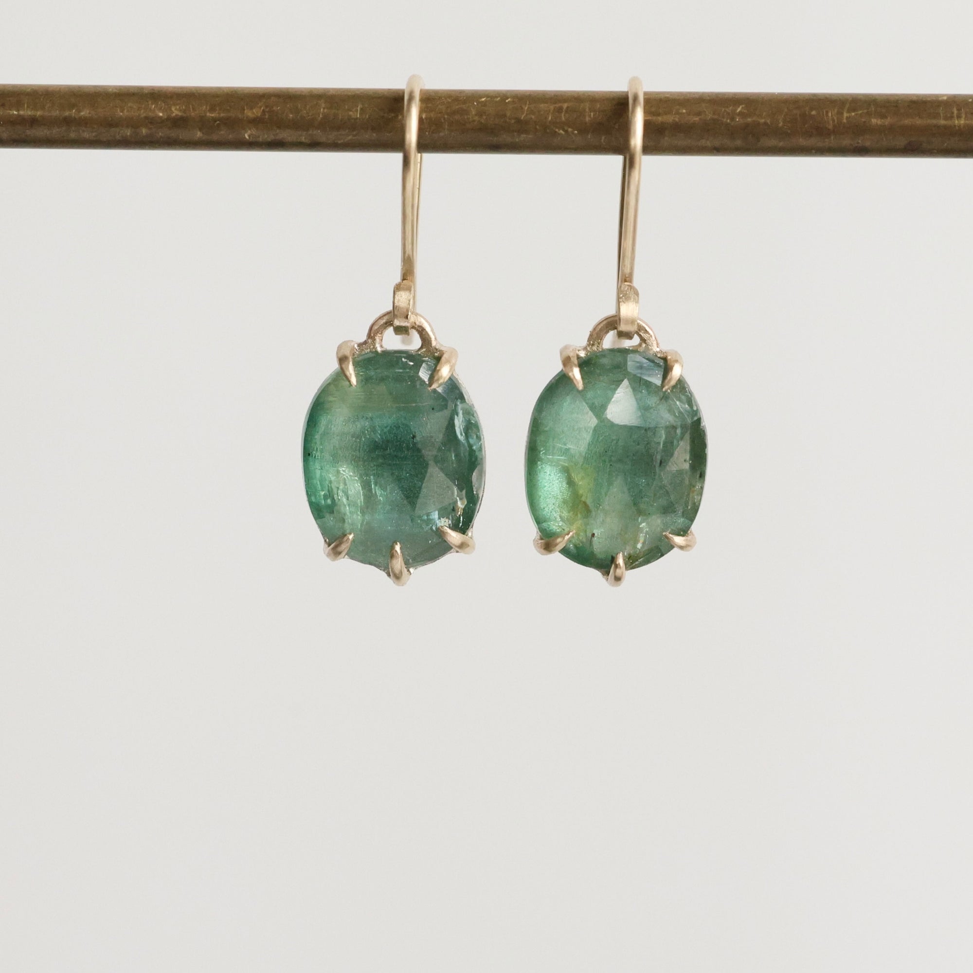Green gemstone earrings on a white background