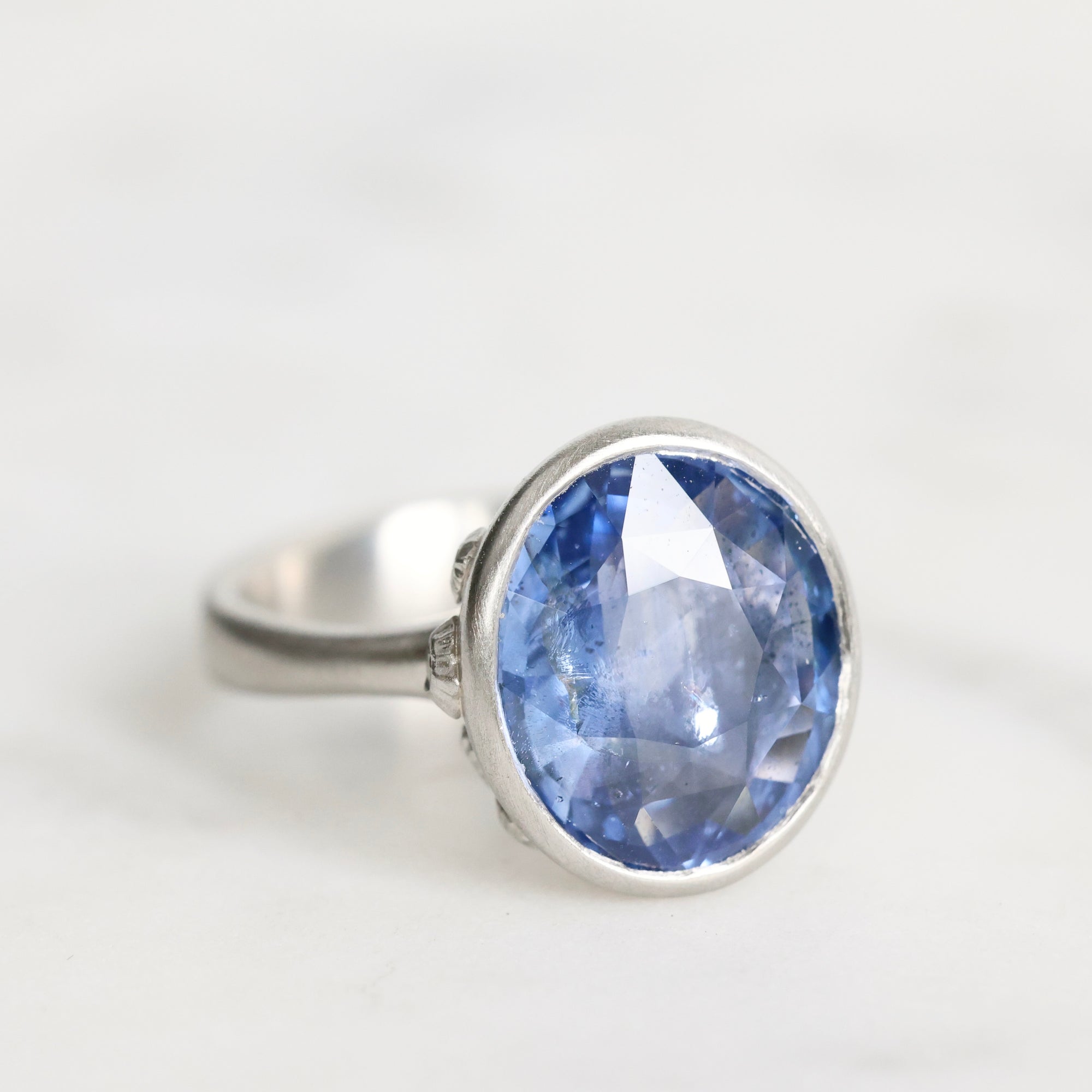 Silver ring with a blue gemstone on a white background