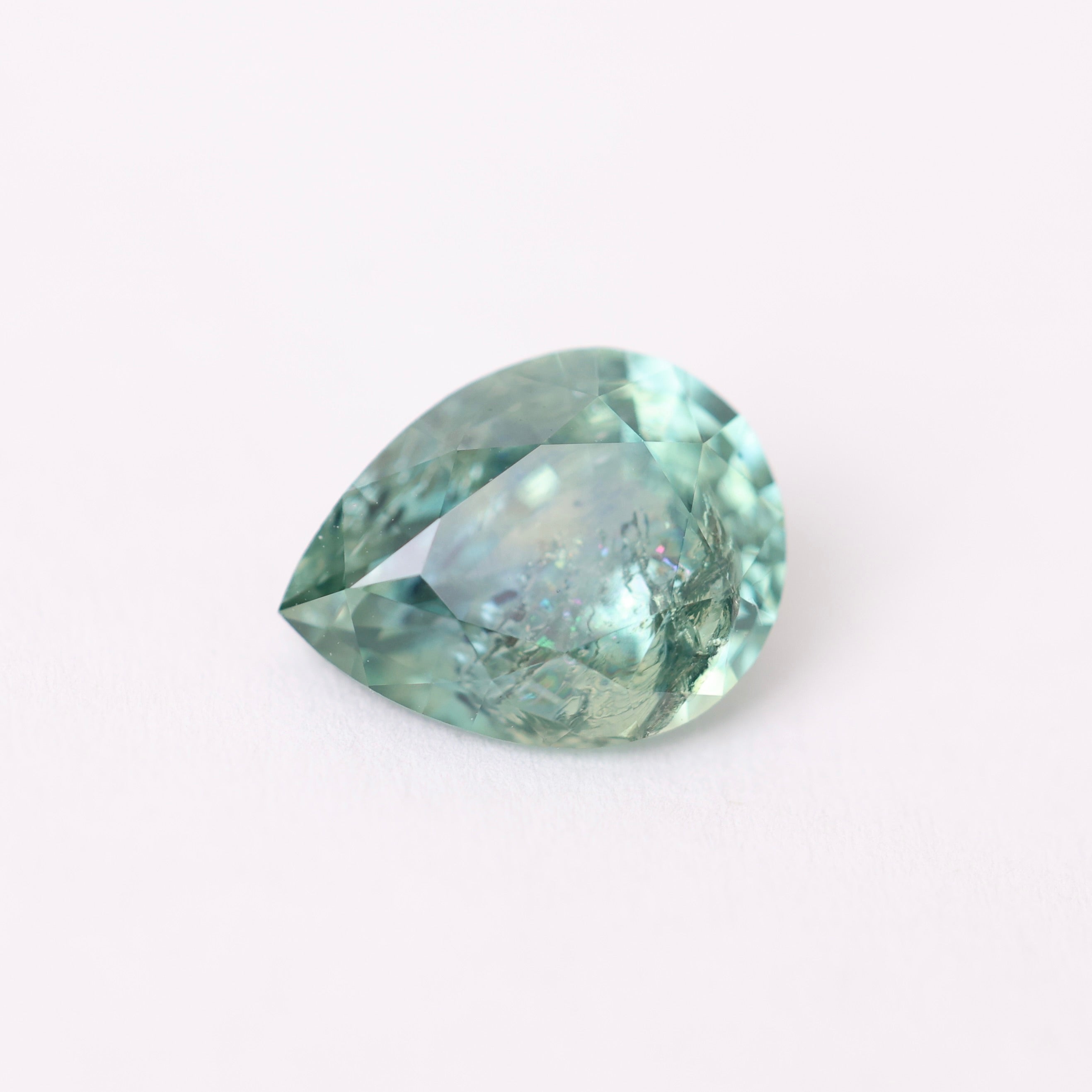Greenish-blue gemstone on a white background