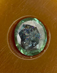 green gemstone in a brown setting