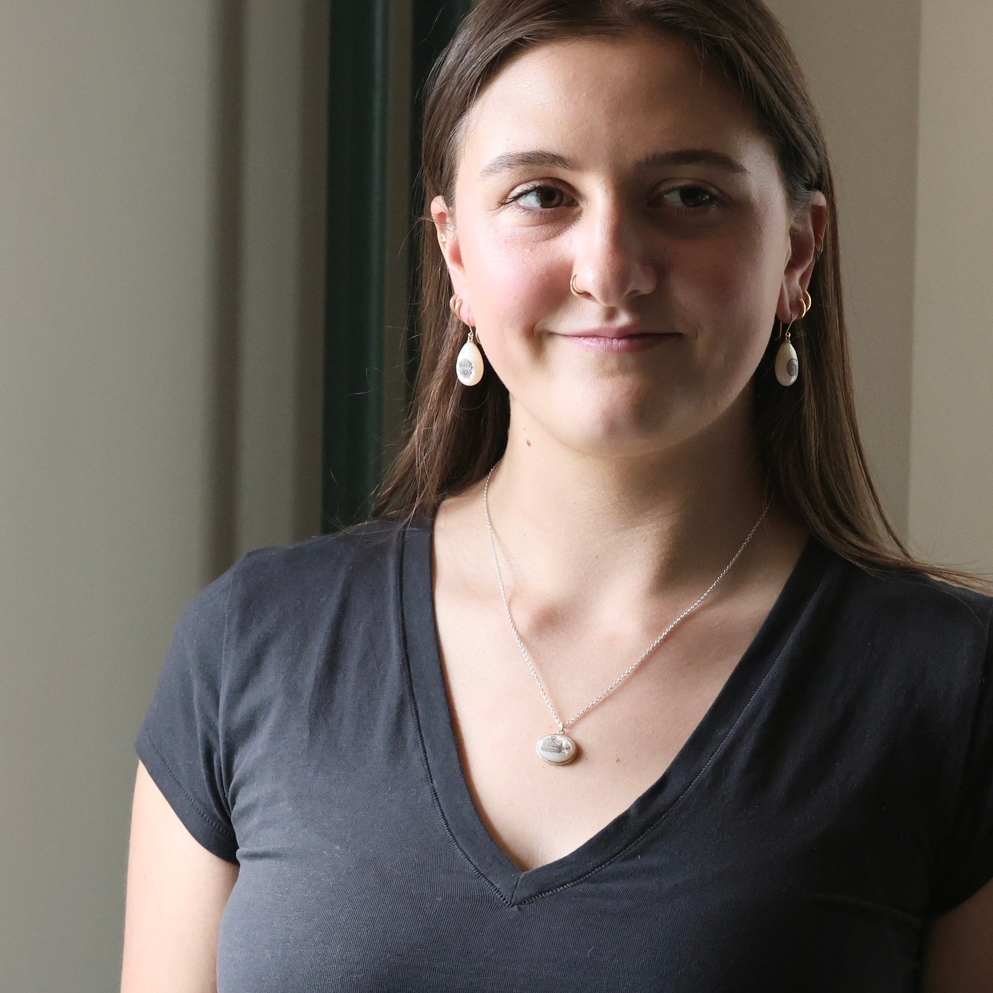 Woman wearing a dark gray shirt with a neutral background