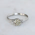 Silver ring with a diamond on a light gray background