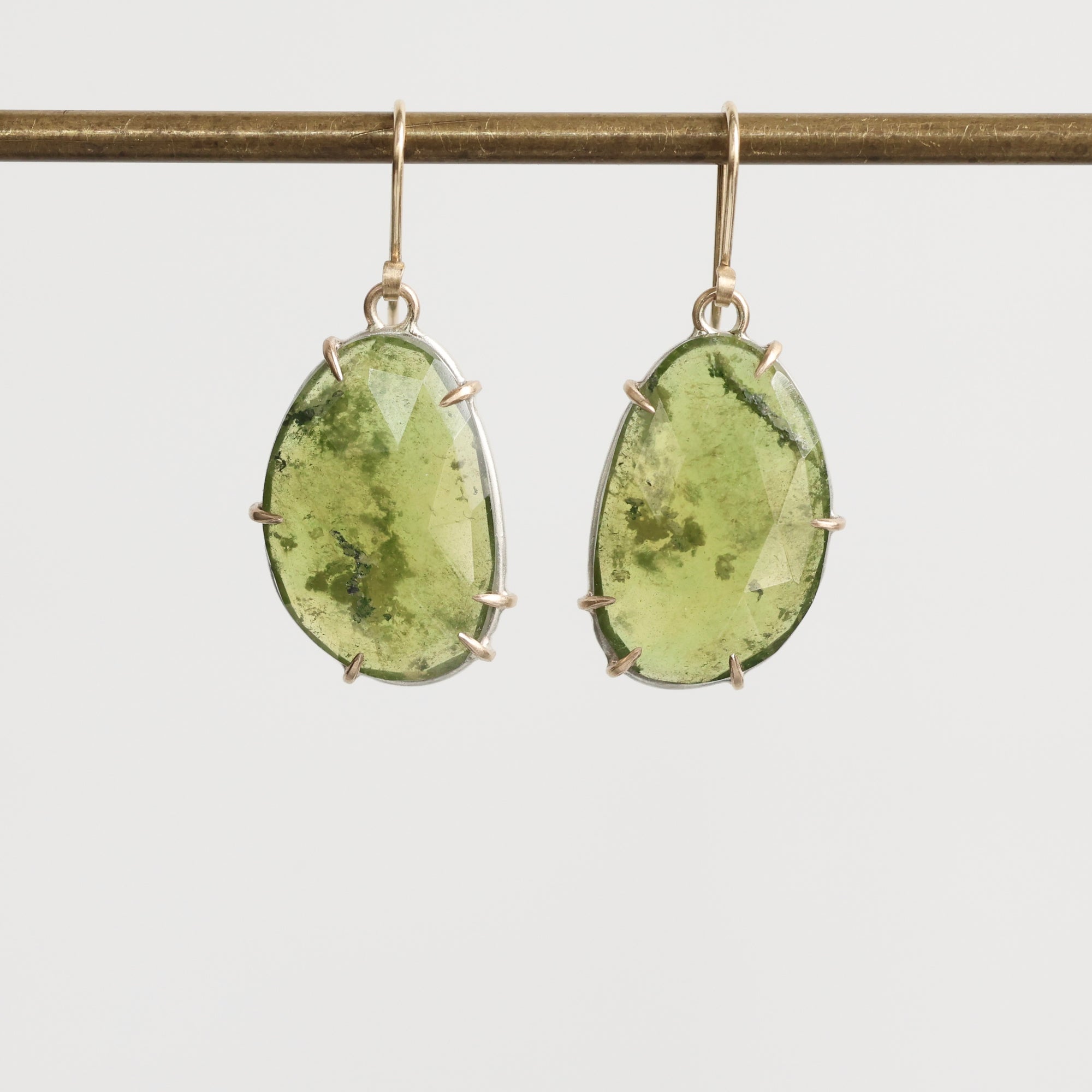 Green gemstone earrings on a white background