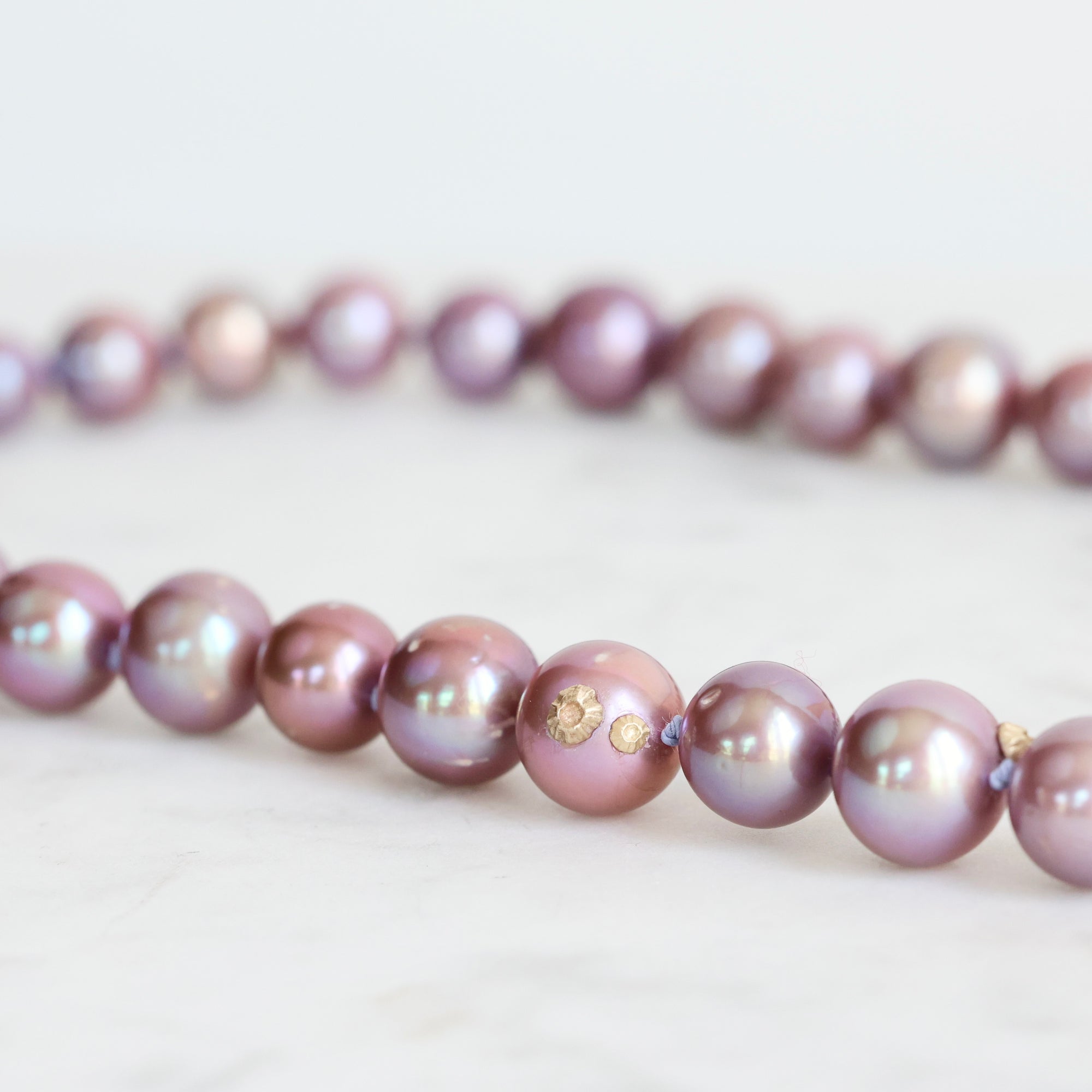 Pink pearl strand with lavender thread and gold barnacles 