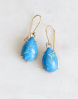 Pair of blue teardrop earrings on a white background