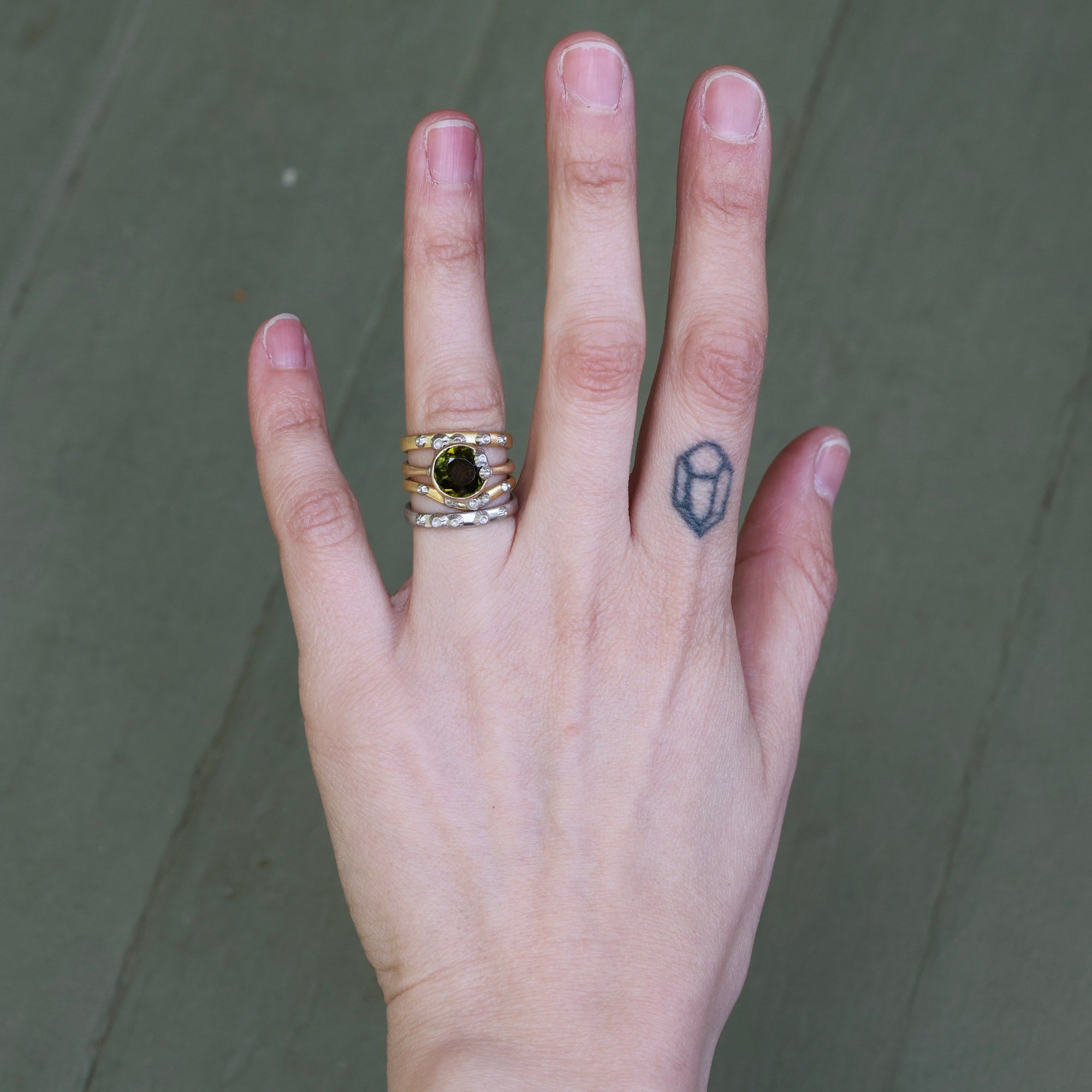 Hand wearing lots of rings stacked 