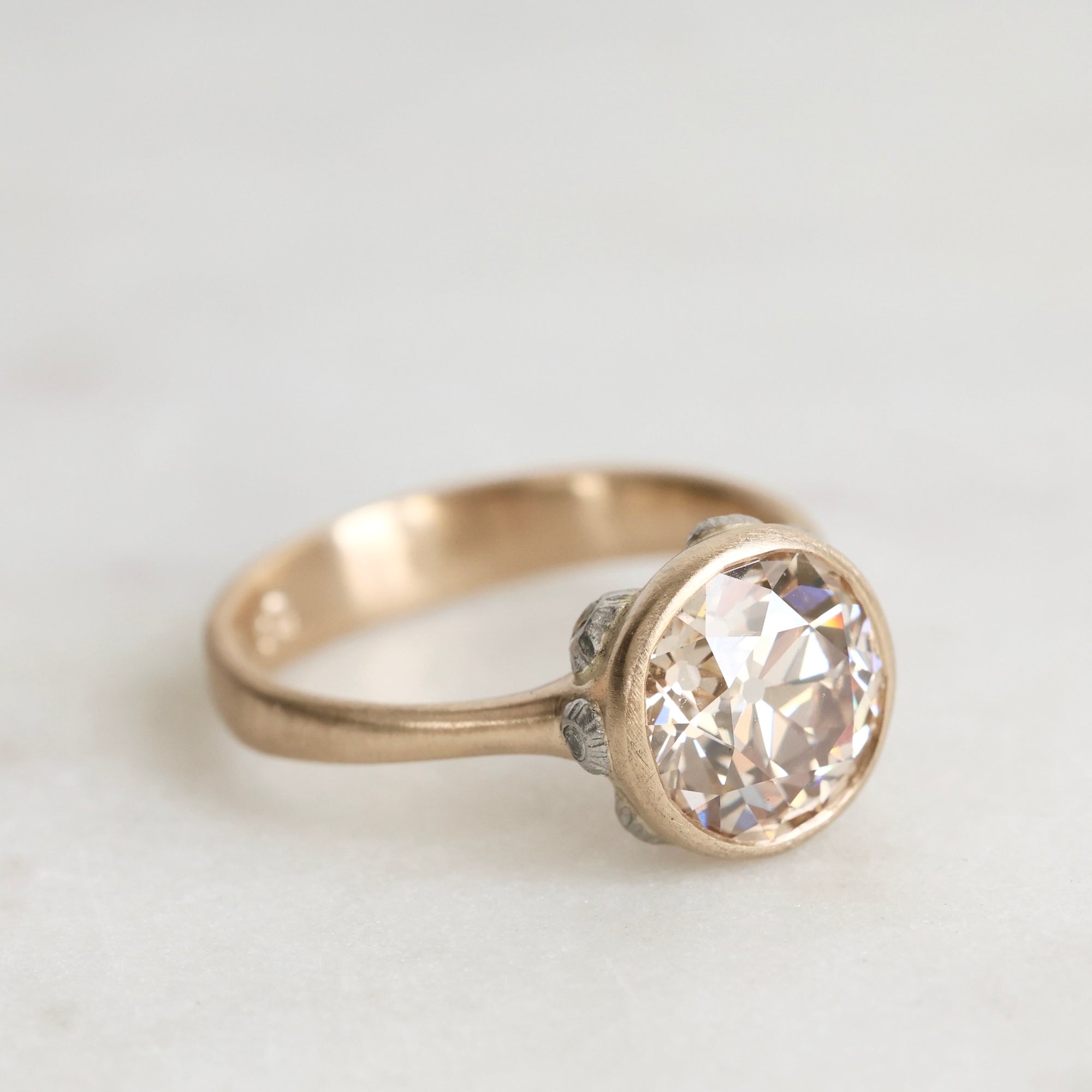 gold ring with a diamond and platinum barnacles against a white background