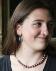 Woman wearing blue teardrop shaped earrings