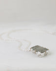Necklace with a rectangular pendant on a light gray background