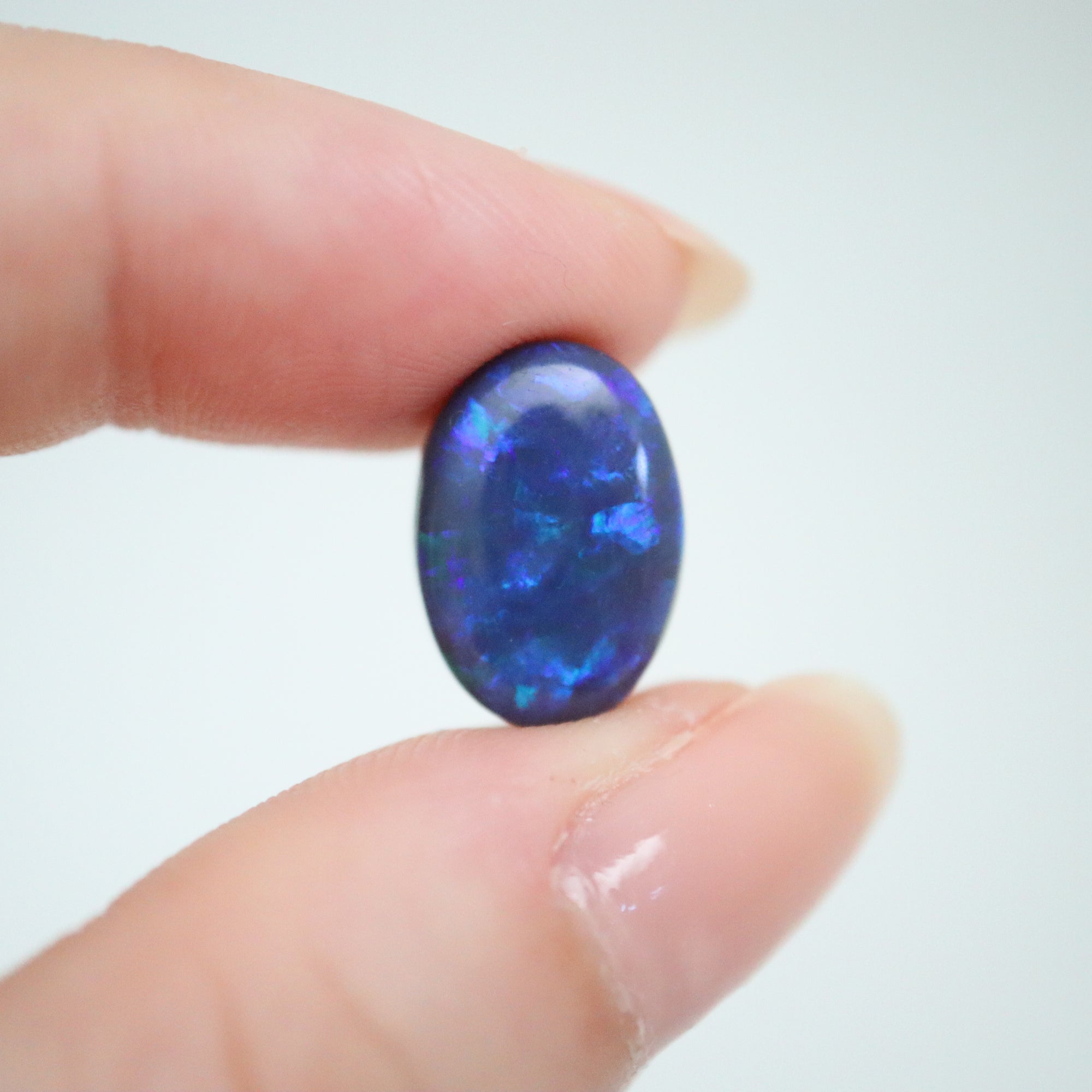 4.65ct Lightning Ridge Black Australian Opal in hand for scale.