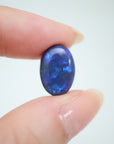 4.65ct Lightning Ridge Black Australian Opal in hand for scale.