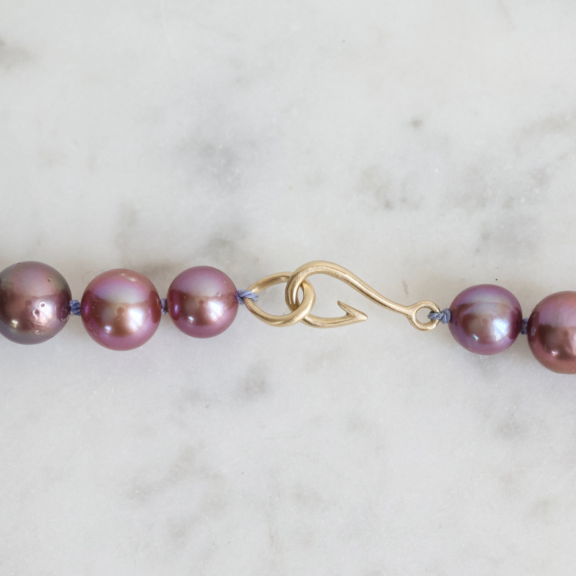 Pink pearl strand with lavender thread and gold barnacles 