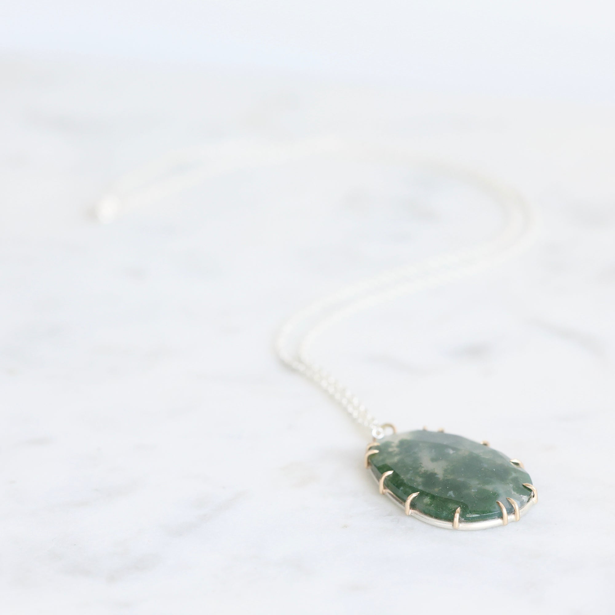 Necklace with a green pendant on a white background